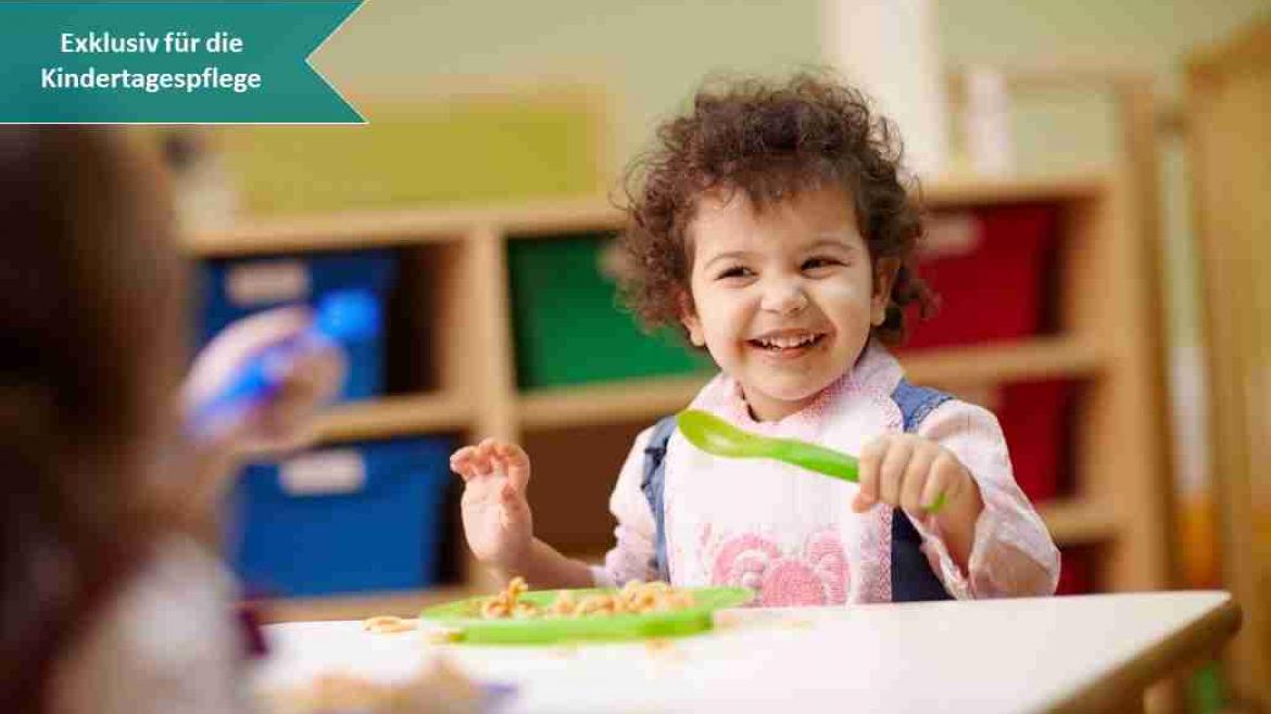 Kind sitzt am Kita Esstissch Tisch und lacht