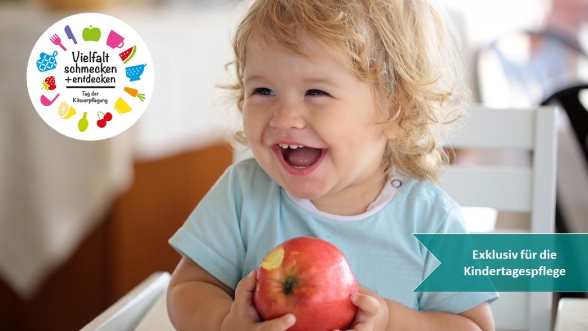 Kind lacht und hat Apfel in der Hand