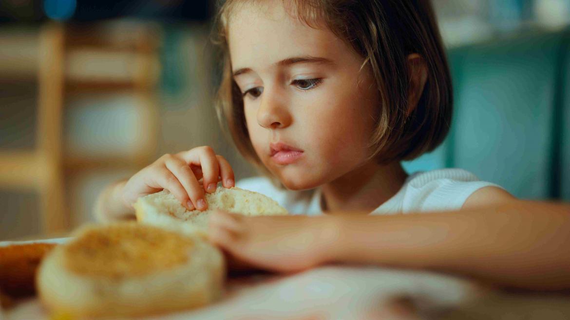 Kind hat Brötchen in der Hand