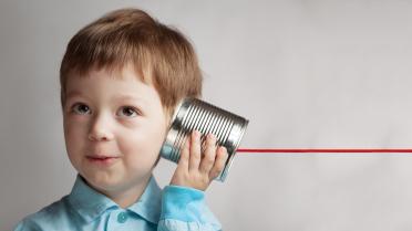 Junge mit Dose am Ohr Dosentelefon