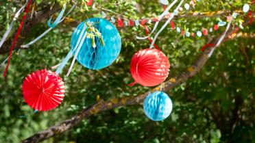 LED Lichtballons in rot und blau wehen im Baum
