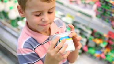 Kind mit süssem Joghurt in der Hand