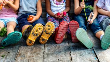 Kindergruppe sitzen. Füße von unten.