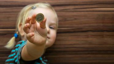 Kind hat Euromünze in der Hand