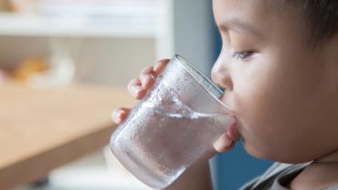 Kind trinkt Wasser aus Glas
