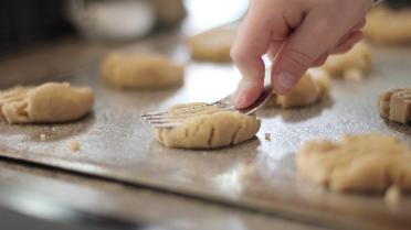 Plätzchen werden mit Gabel plattgedrückt