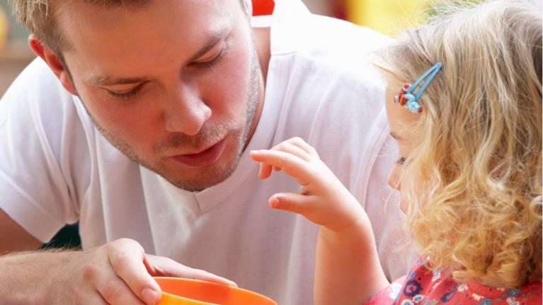 Kind und Kitaerzieher - Kind isst aus einer orangenen Schüssel