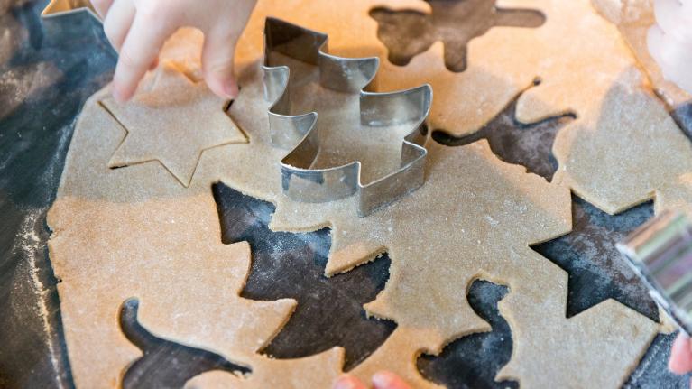 Kinderhände stechen Plätzchen aus Weihnachtsbäume 