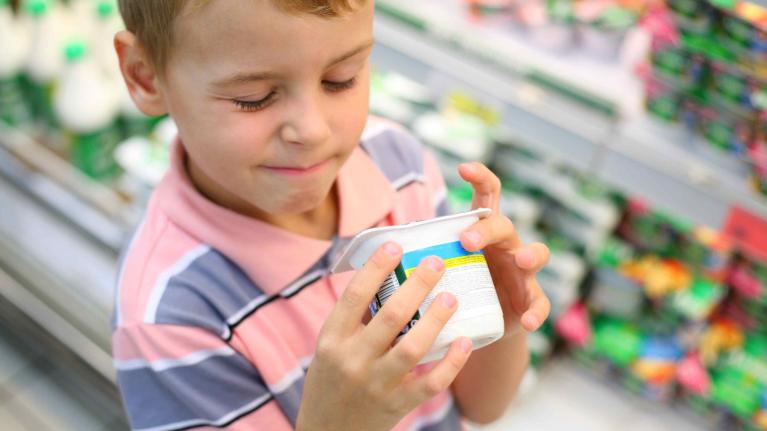 Kind mit süssem Joghurt in der Hand