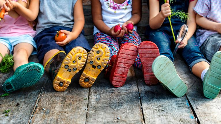 Kindergruppe sitzen. Füße von unten.