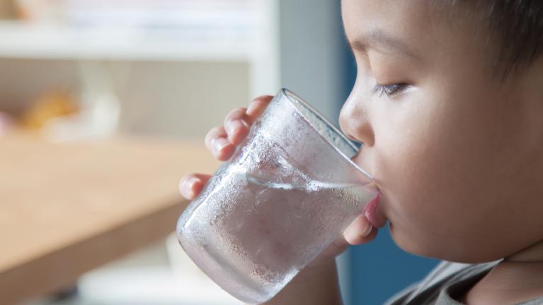 Kind trinkt Wasser aus Glas