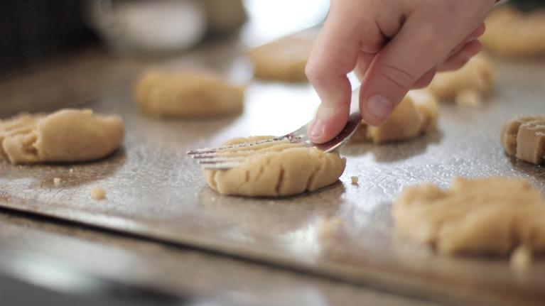 Plätzchen werden mit Gabel plattgedrückt