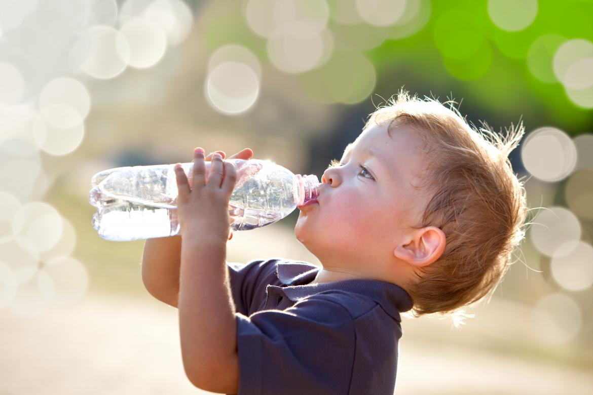 Junge trinkt einen Schluck aus der Wasserflasche