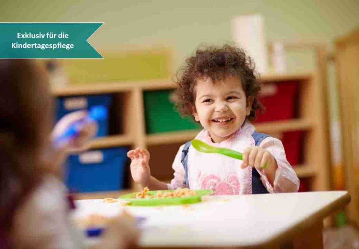 Kind sitzt am Kita Esstissch Tisch und lacht