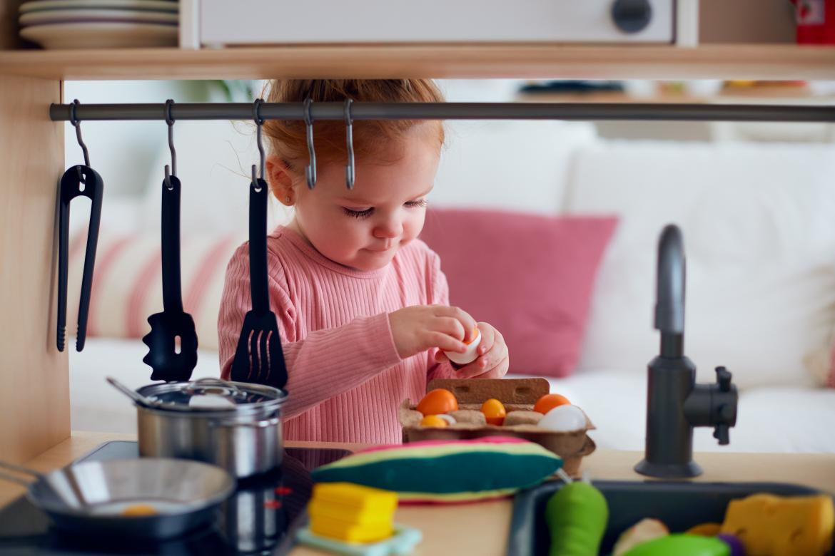 Kind Spielt in einer Puppenküche mit Plastikeiern