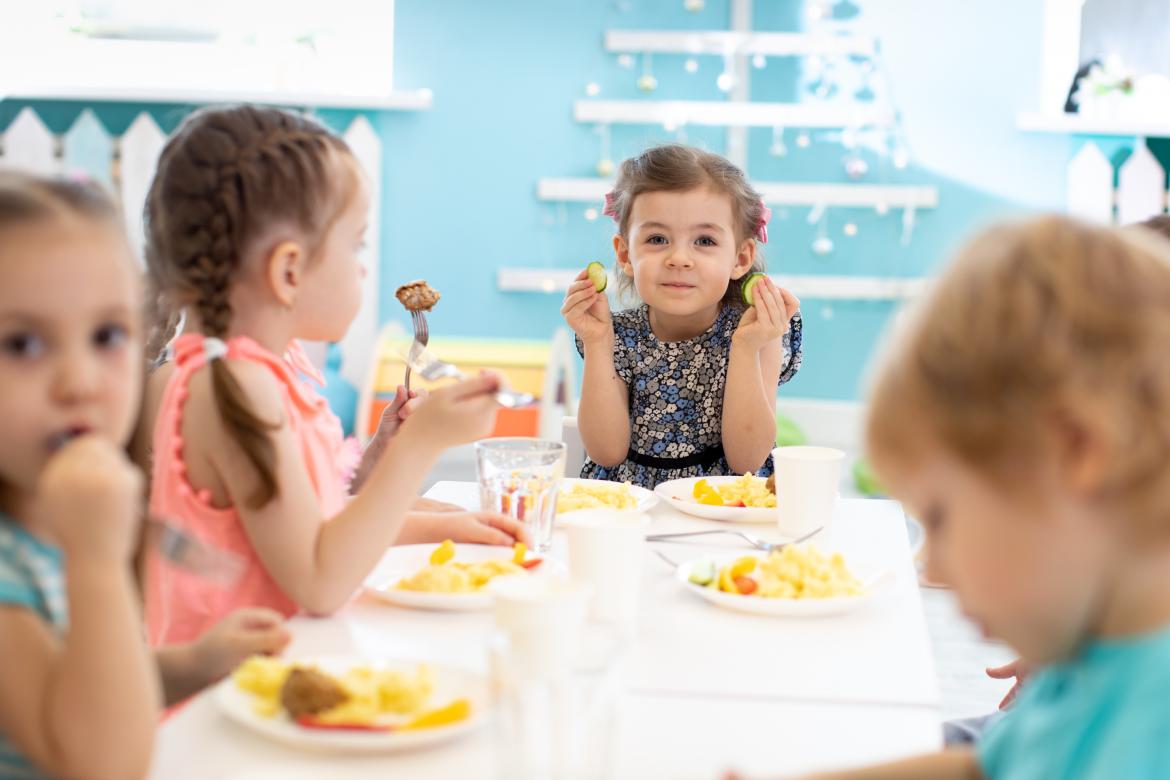 Kinder essen in der Kita am Tisch