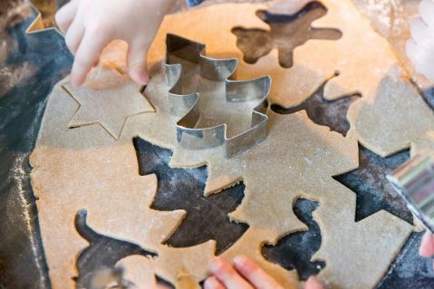 Kinderhände stechen Plätzchen aus Weihnachtsbäume