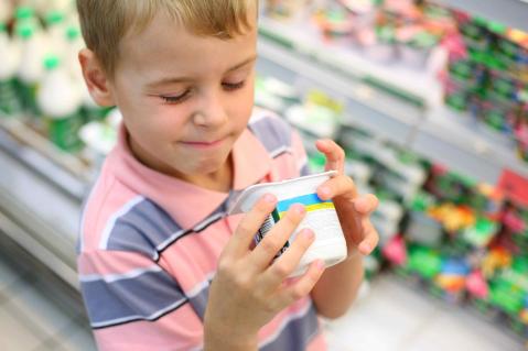 Kind mit süssem Joghurt in der Hand