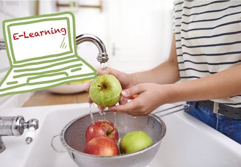 Frau wäscht Tomaten im Waschbecken über einem Haarsieb. Das Gexicht der Frau ist nicht zu sehen, sondern nur die Hände. Sie trägt eine Jeans und ein weiß-schwarz gestreiftes T-Shirt.