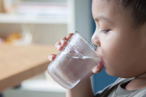 Kind trinkt Wasser aus Glas